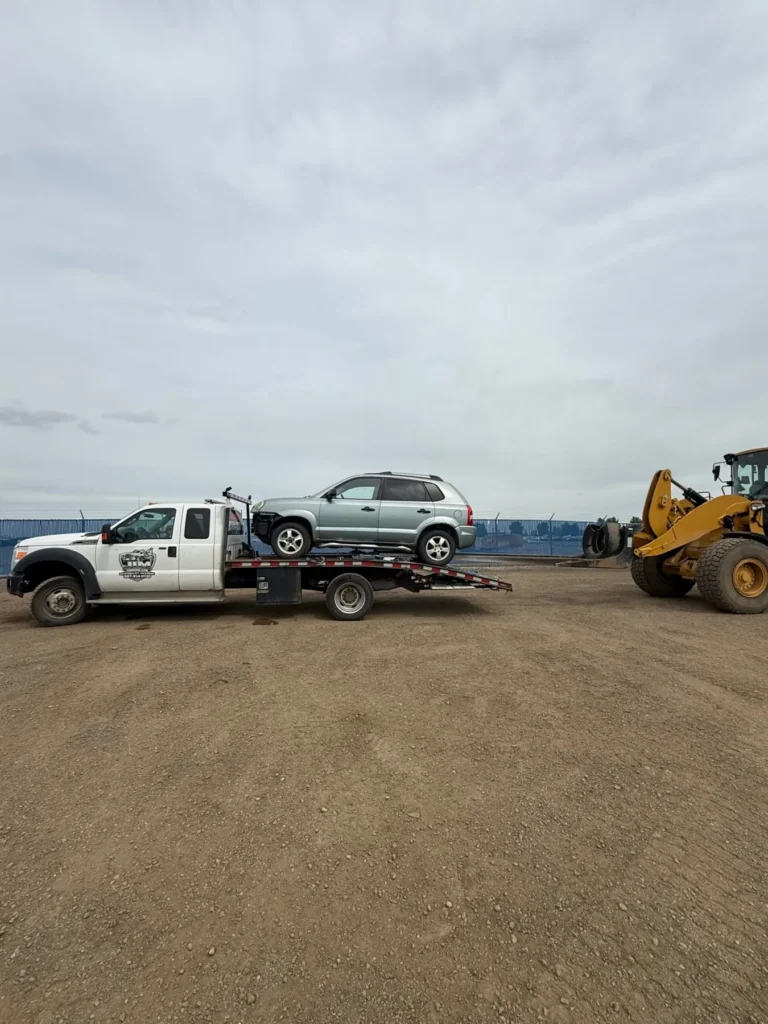 Jim Towing flatbed transporting a vehicle across Alberta