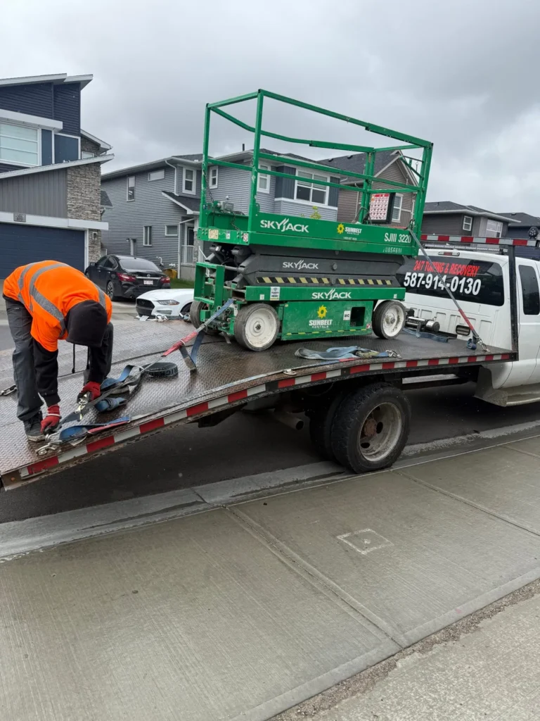 Jim Towing operator loading a scissor lift onto the flatbed